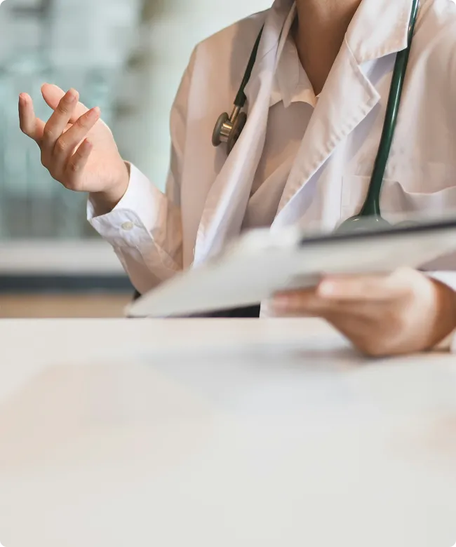 SmartCare Rx Pharmacy doctor with a stethoscope discussing medical records during a patient consultation, highlighting attentive and professional healthcare