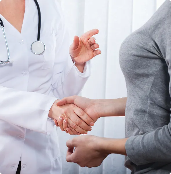 SmartCare Rx Pharmacy doctor warmly greeting a patient with a handshake during a clinical consultation, highlighting personalized and welcoming healthcare