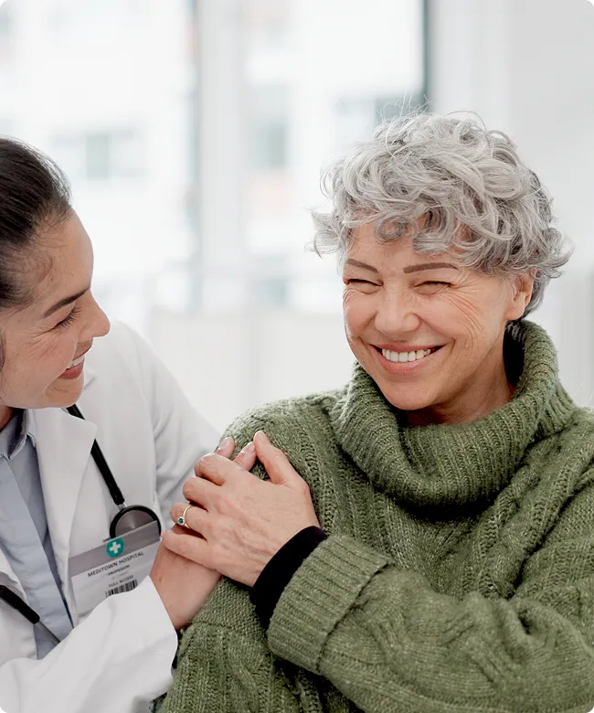 SmartCare Rx Pharmacy smiling senior woman in a green sweater receiving a vaccination from a healthcare professional, highlighting patient comfort and immunization services