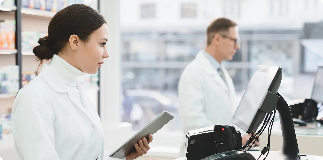 SmartCare Rx Pharmacy pharmacist in a white coat reviewing a prescription list while organizing medication boxes in a pharmacy drawer, highlighting accurate inventory management and personalized pharmaceutical care