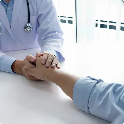 SmartCare Rx Pharmacy doctor gently holding a patient’s hand during a comforting consultation, emphasizing compassionate and supportive healthcare