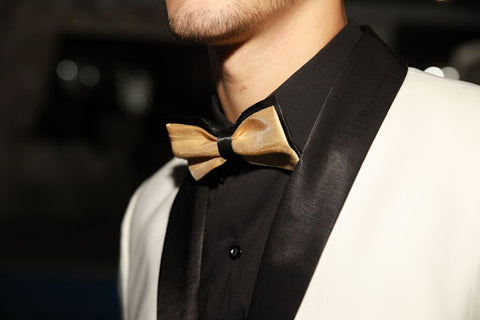 gold bow tie with black shirt and white jacket