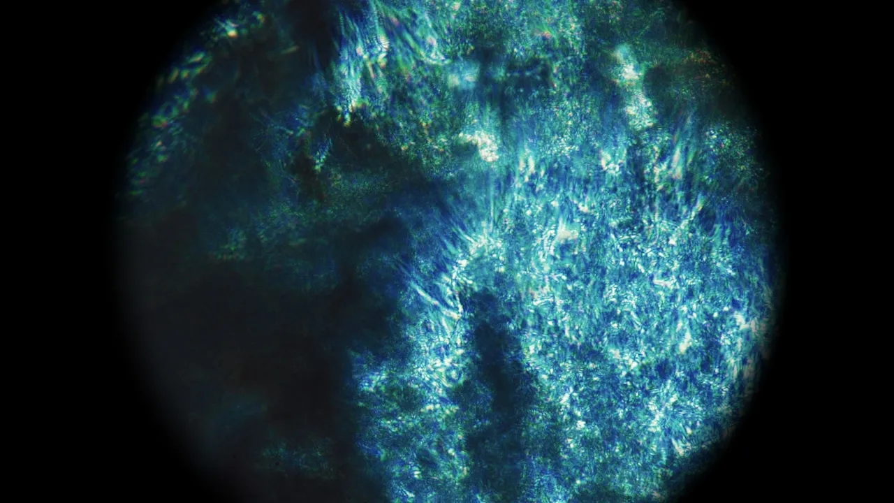 Abstract glowing blue and green crystalline texture with luminous particles on dark background