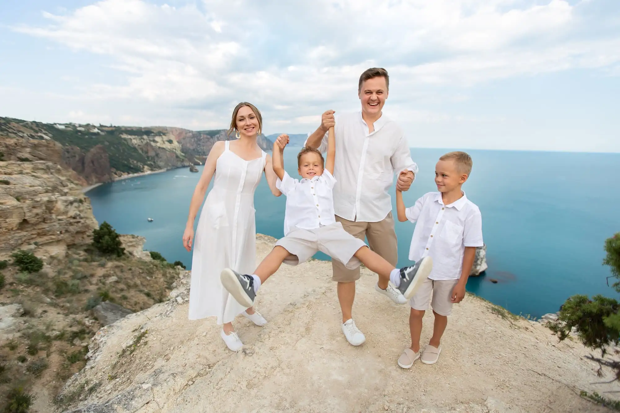 family on top of cliff by the ocean