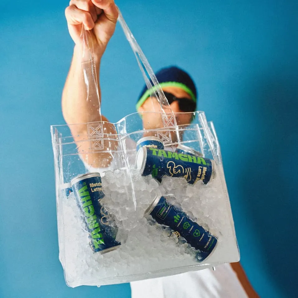 Homme tenant un sac de glaçons avec des canettes de iced matcha latte avoine tamcha