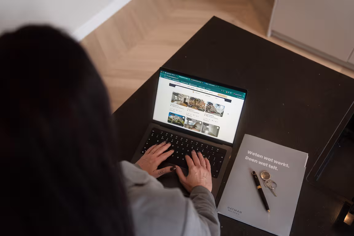 Makelaar van HAYMAN zet het woningaanbod online, met de verkoopmap en de sleutels op tafel