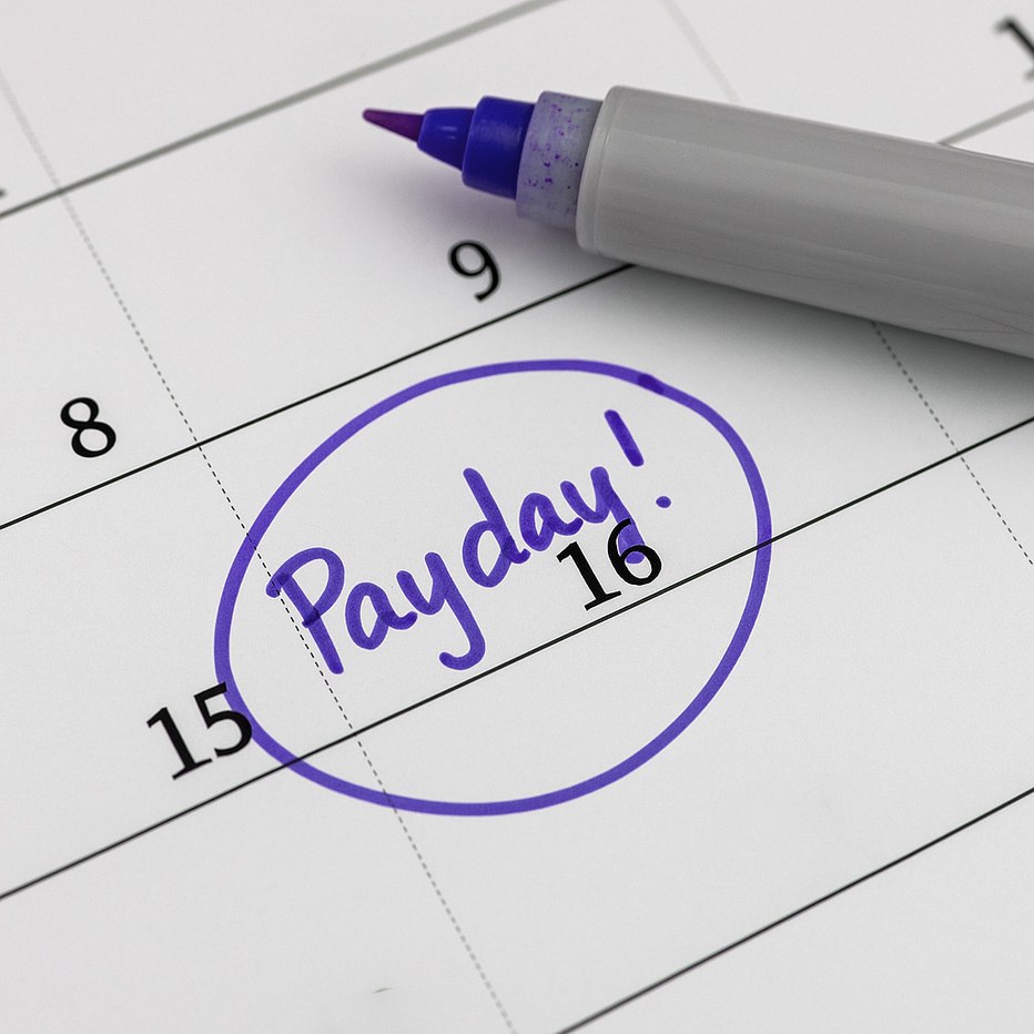 Calendar with the word "Payday!" circled in purple on the 16th, next to a purple marker.