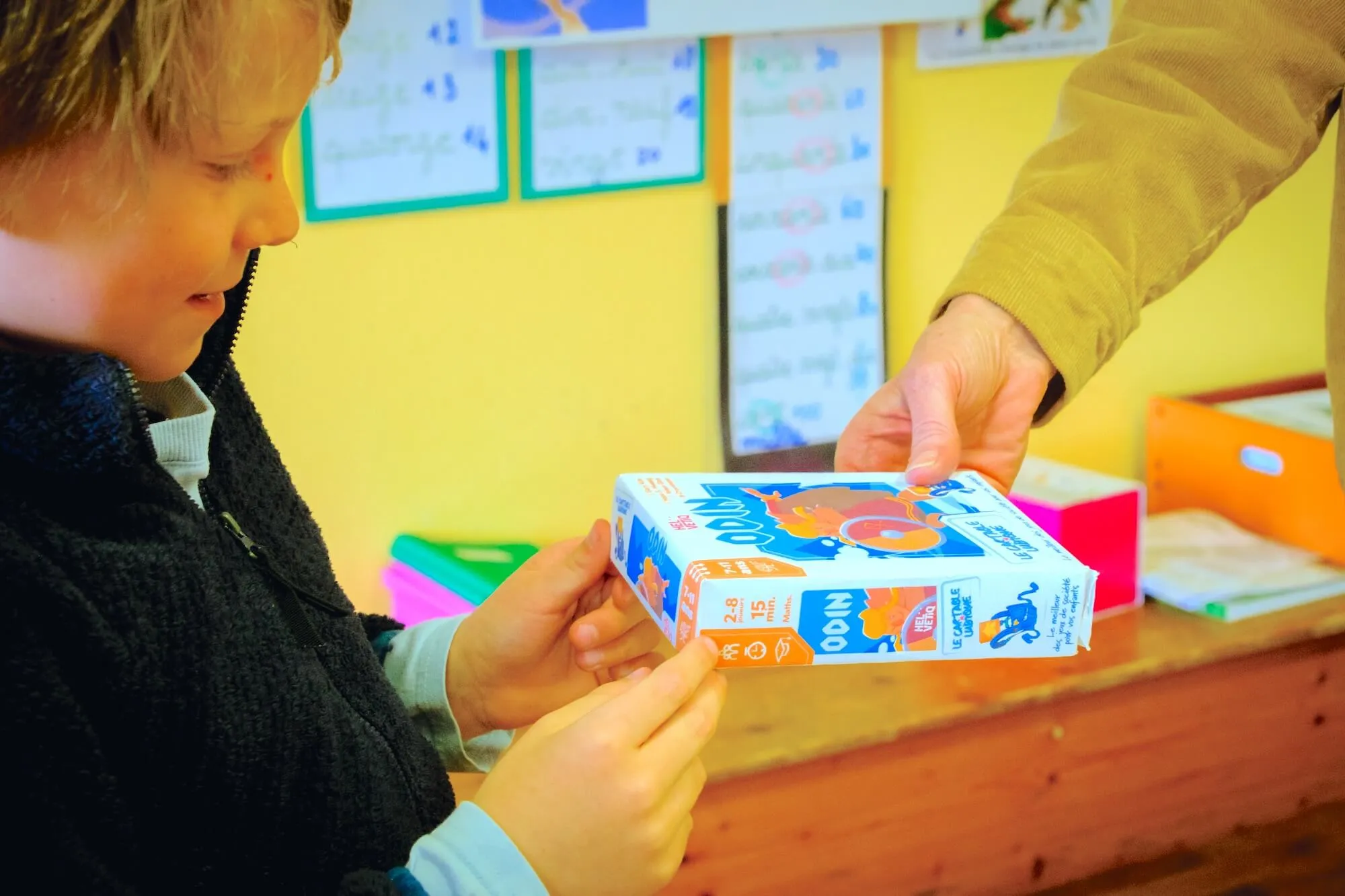 Un enfant reçoit son jeu Cartable Ludique à l'école