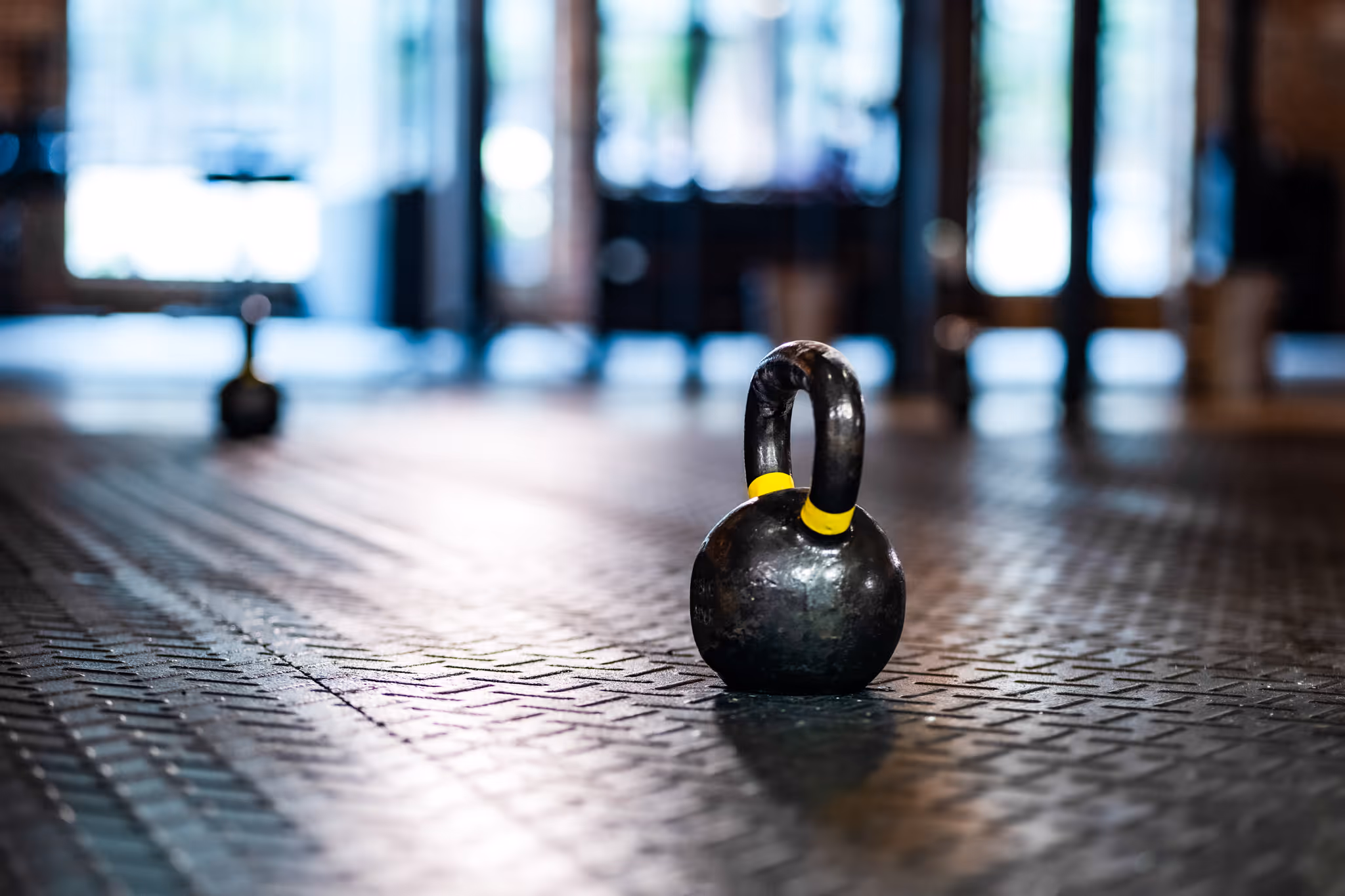 Close-up view of a Rogue Infinity power rack with gymnastic rings hanging in a gym.