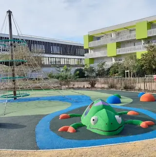 aire de jeux de la Place Dulong à Floirac pour les enfants de moins de 3 ans, avec balançoires, filets d'escalade et boules à monter/descendre.