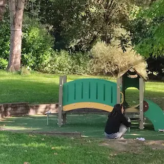 aire de jeux discrète et ombragée dans le parc Castel à Floirac, avec un petit pont et un toboggan.