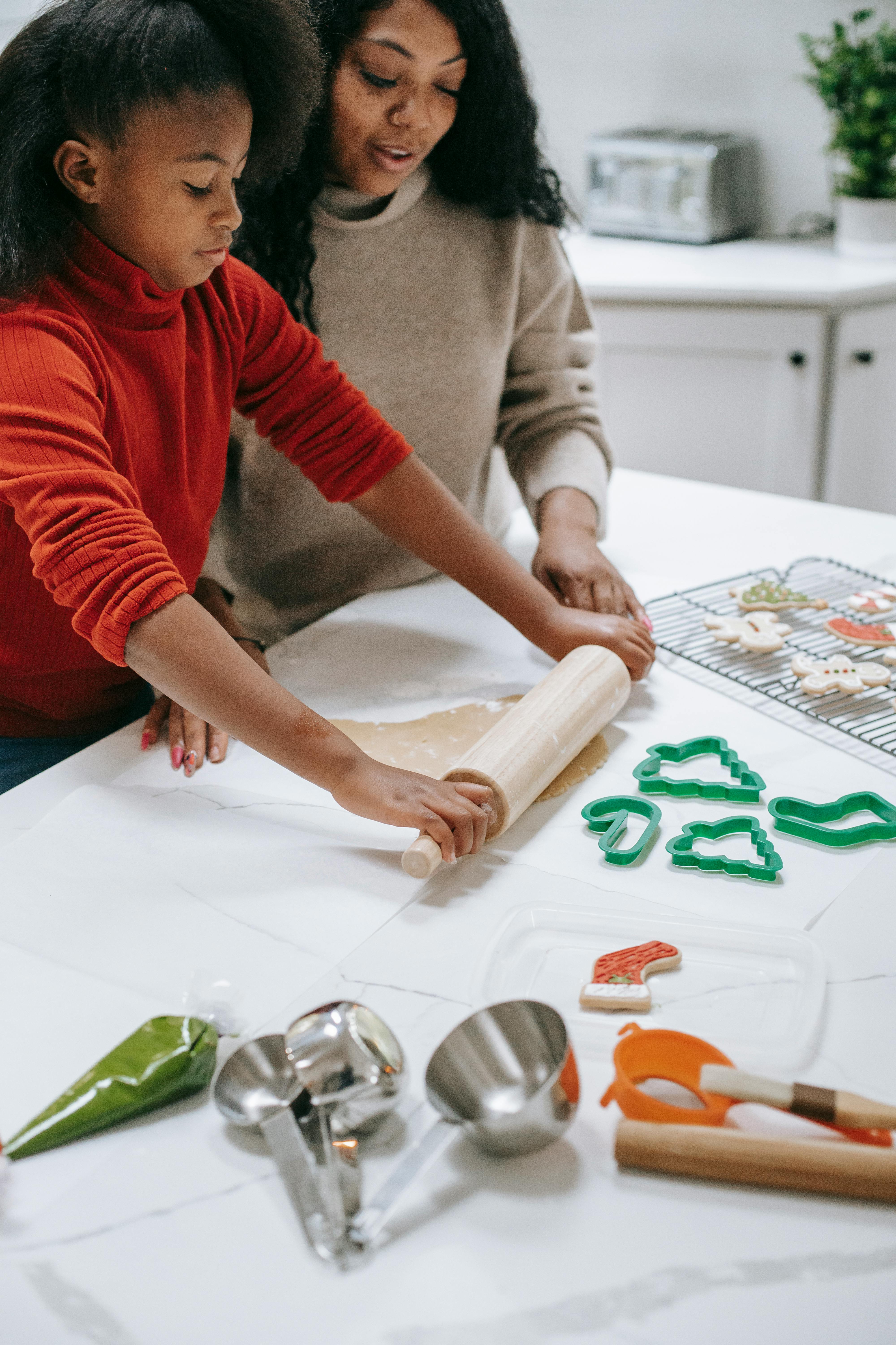 mom and daughter making cookies together for the holidays