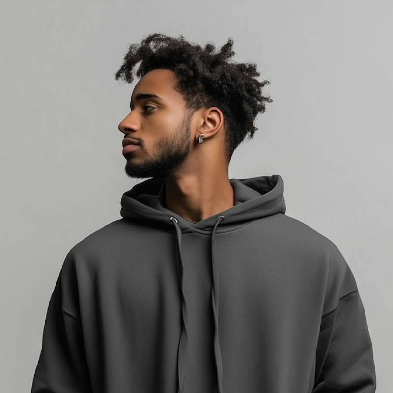 A man with dreadlocks wearing a grey hoodie.
