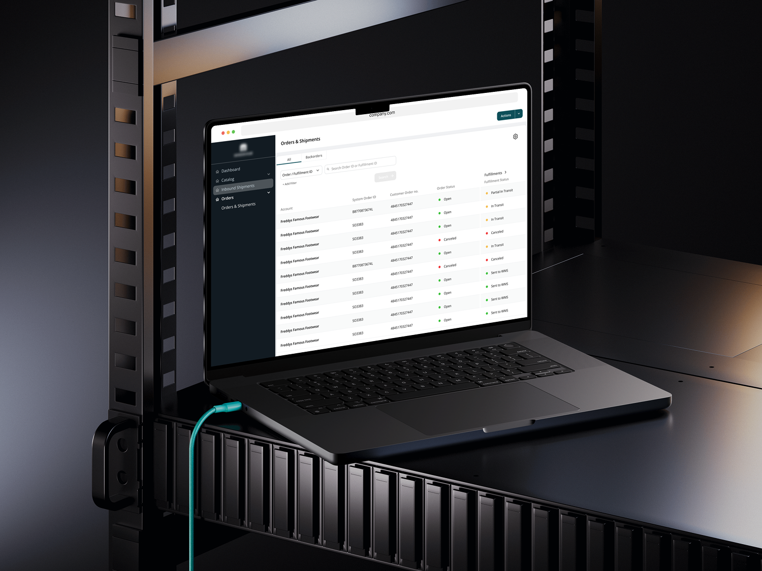 A black laptop sits on a server rack shelf, displaying a data interface. A bright blue cable connects to the laptop, suggesting an IT or data center setting.