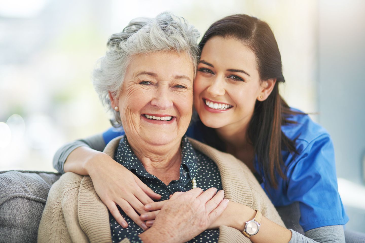 Mitarbeiterin nimmt Seniorin in den Arm