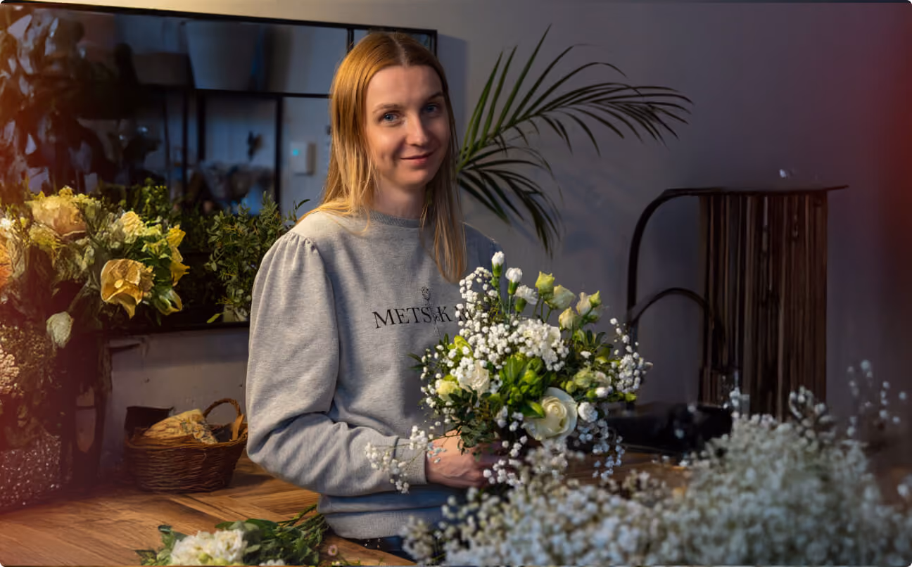 Florist Metsik Roosist valmistamas valgete rooside ja kipslillede kimpu