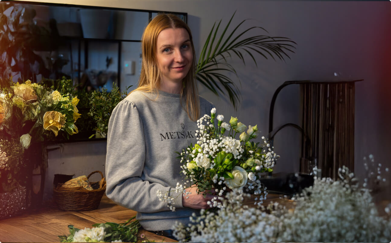 Florist Metsik Roosist valmistamas valgete rooside ja kipslillede kimpu
