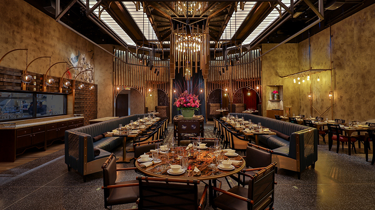 A large dining room with a chandelier hanging from the ceiling.