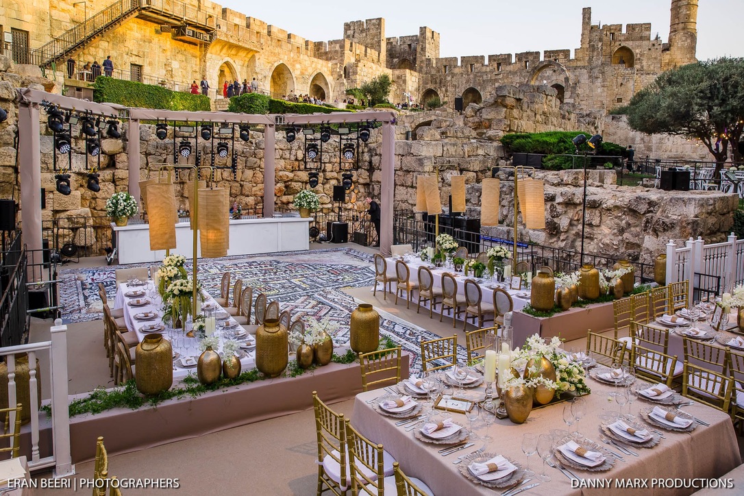 Elevated view of mosaic dance floor, lanterns, and banquet tables.
