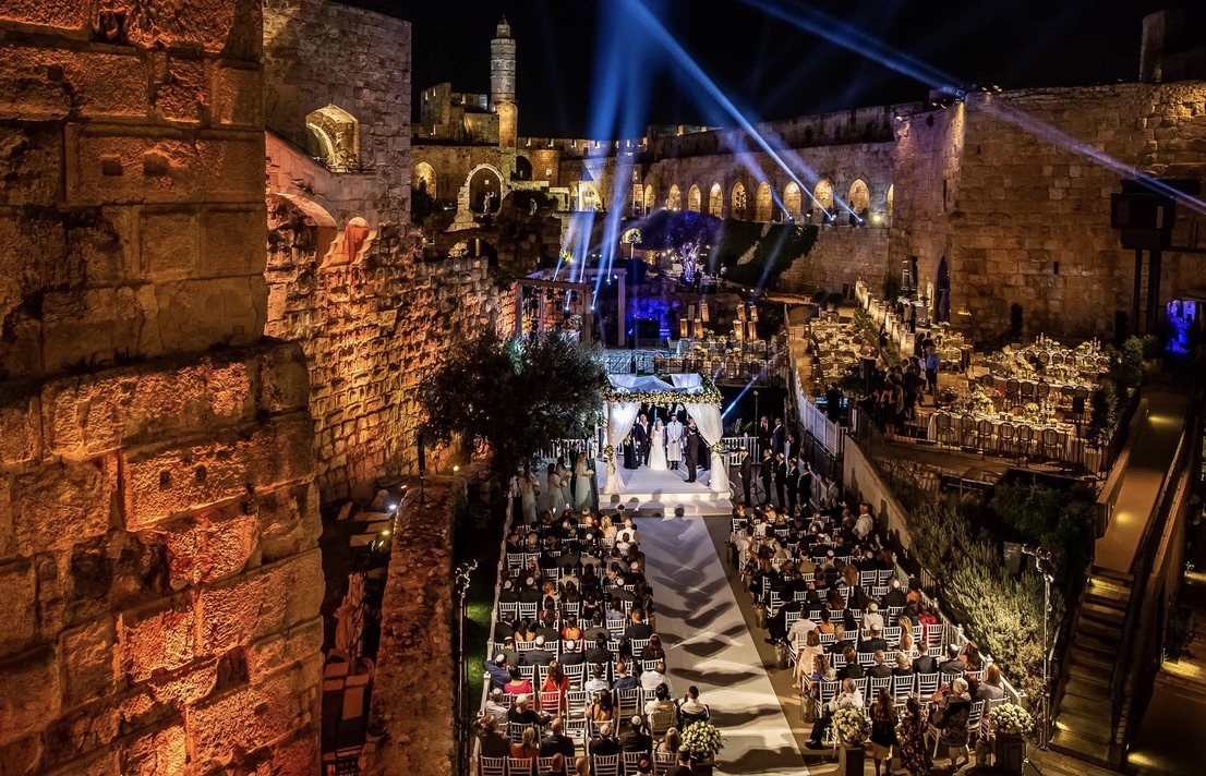 Tower of David wedding ceremony with dramatic lighting and full audience.