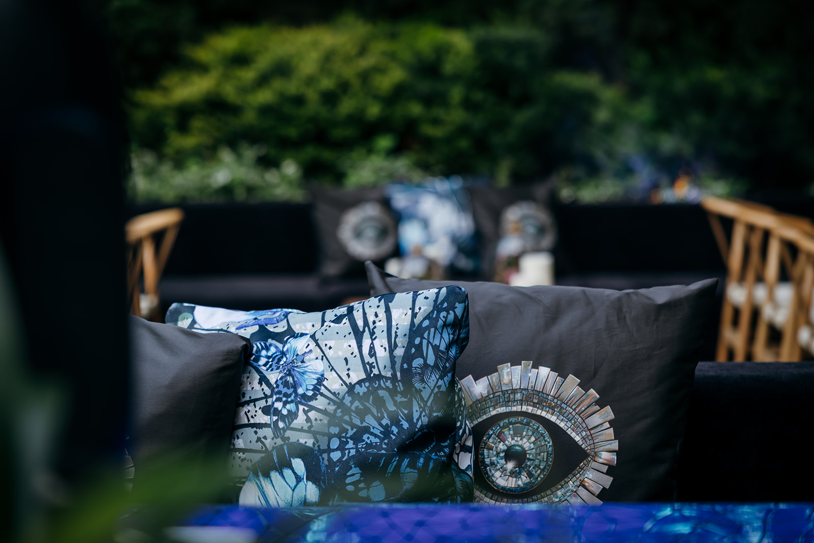Custom throw pillows featuring a butterfly pattern and a mosaic eye design, part of the unique wedding lounge decor for an Israel wedding.