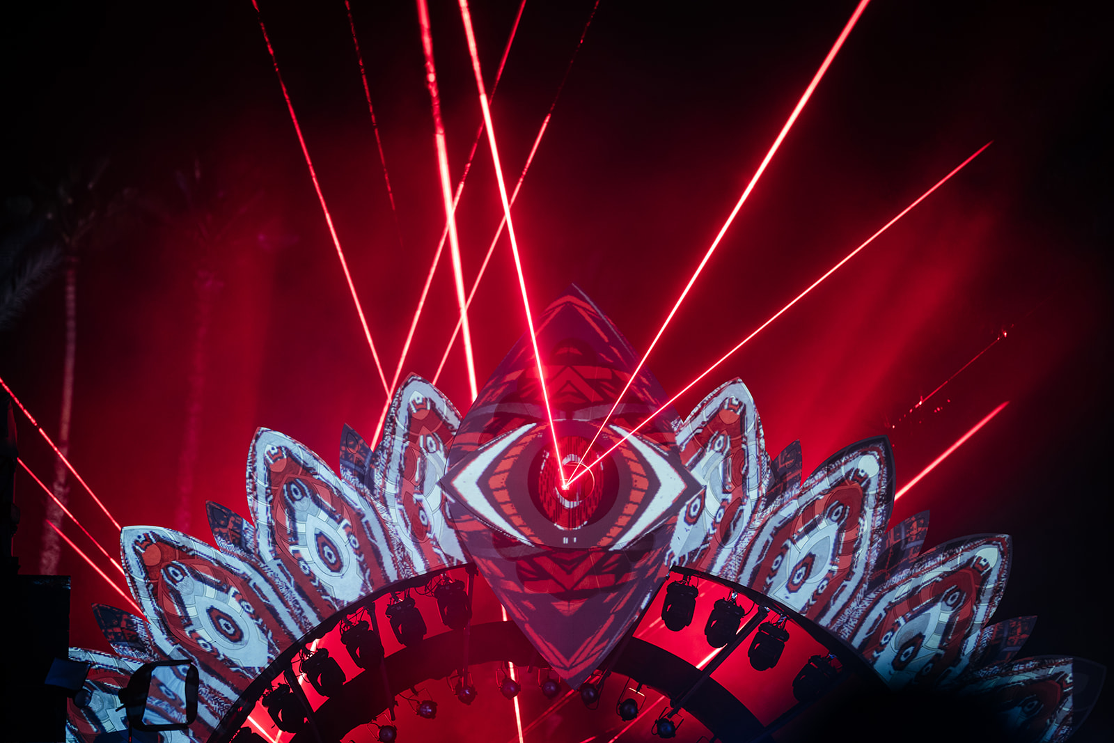 Detailed shot of the wedding party stage design in Israel, featuring a striking red eye motif and powerful laser light effects. Luxury wedding decor.