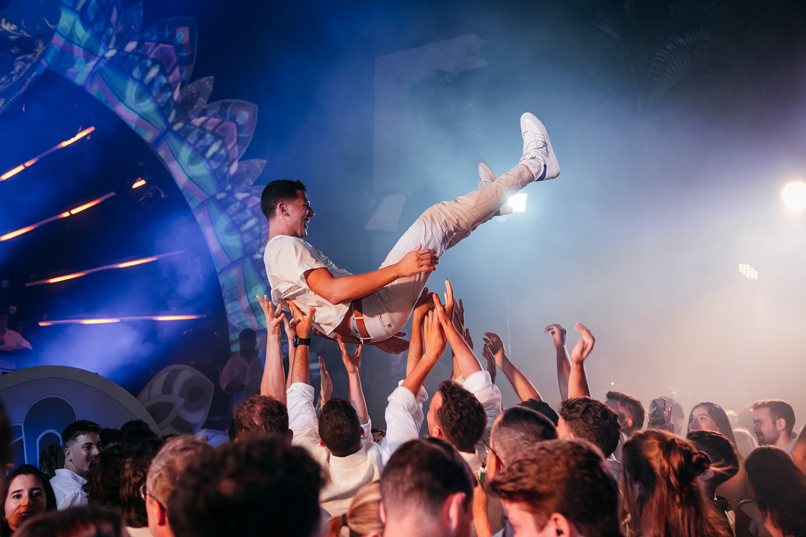 Groom being lifted high in the air by friends during the traditional Hora dance at an energetic Jewish wedding reception in Israel.