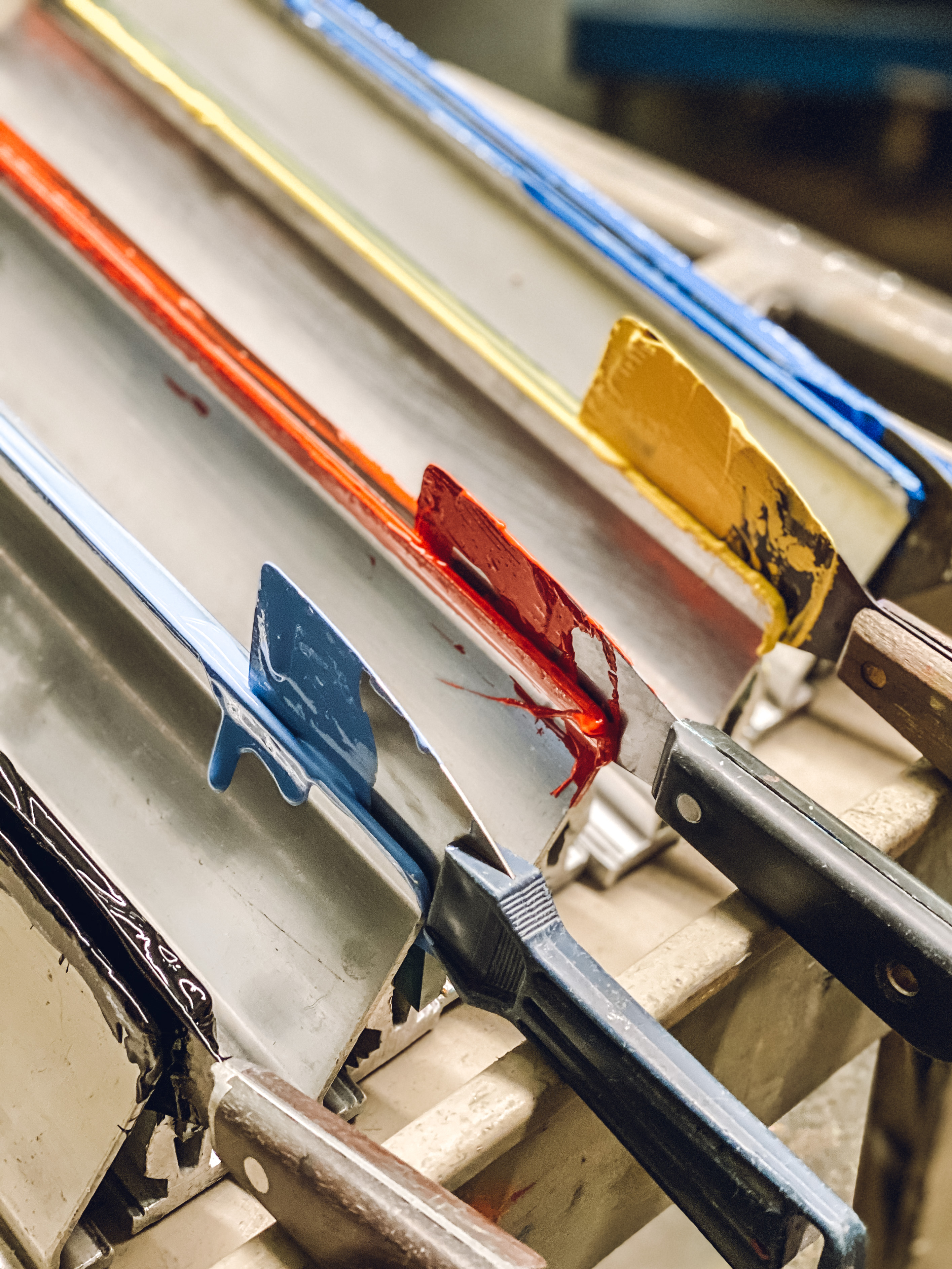 Screen printing squeegees lined up in a print shop