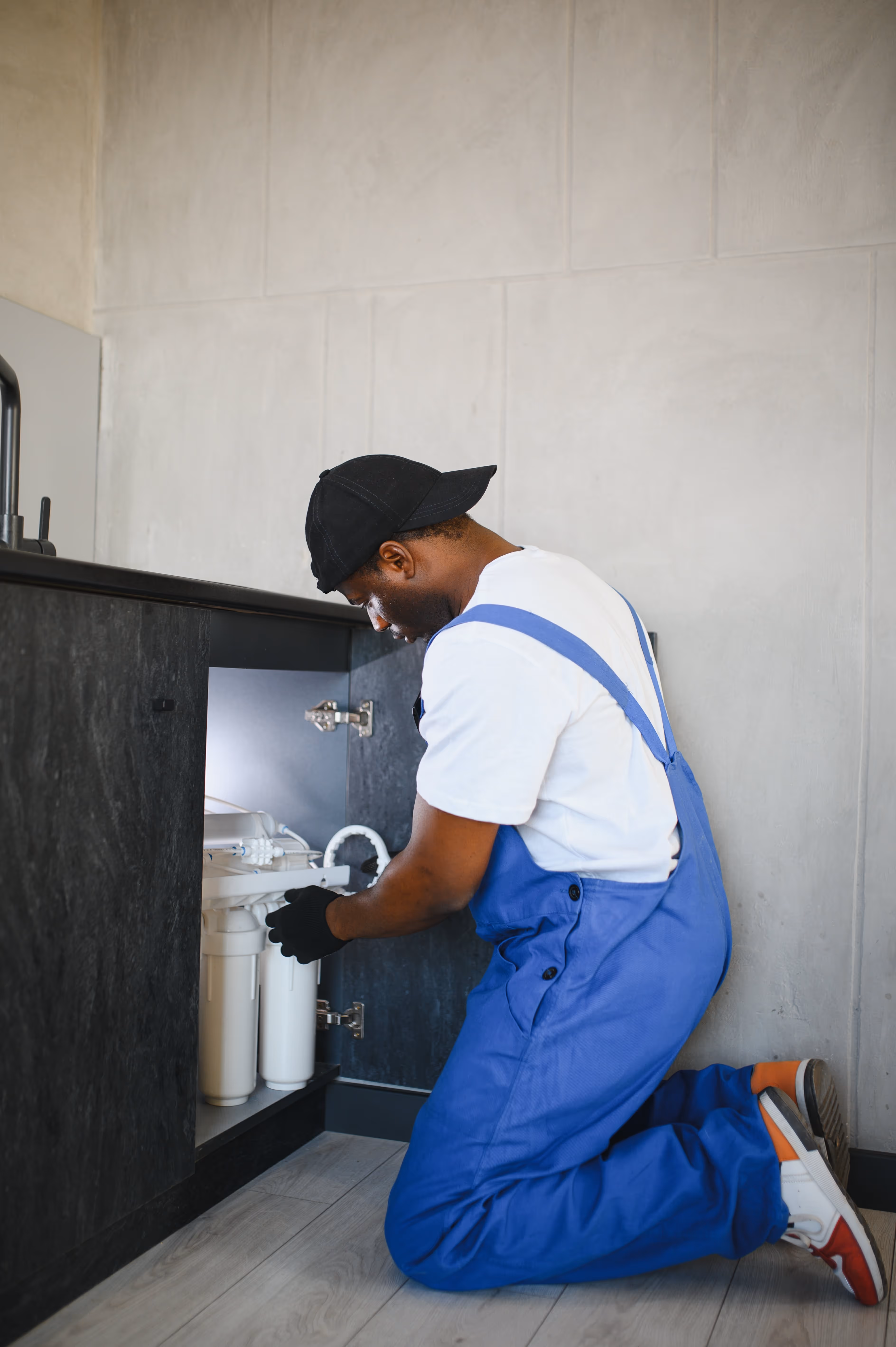 Plumber installing water filter.