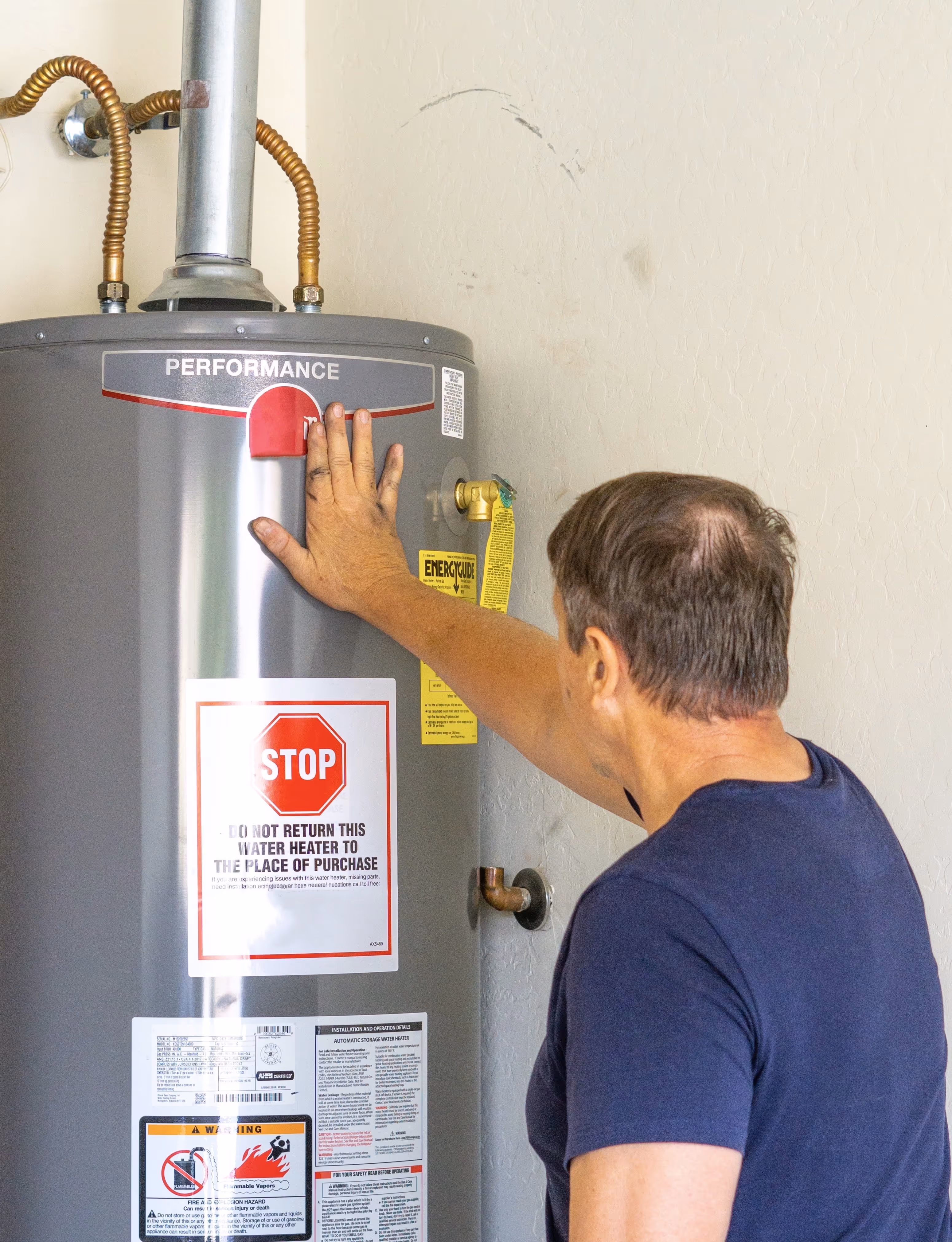 A technician feeling the temperature of a water heater.