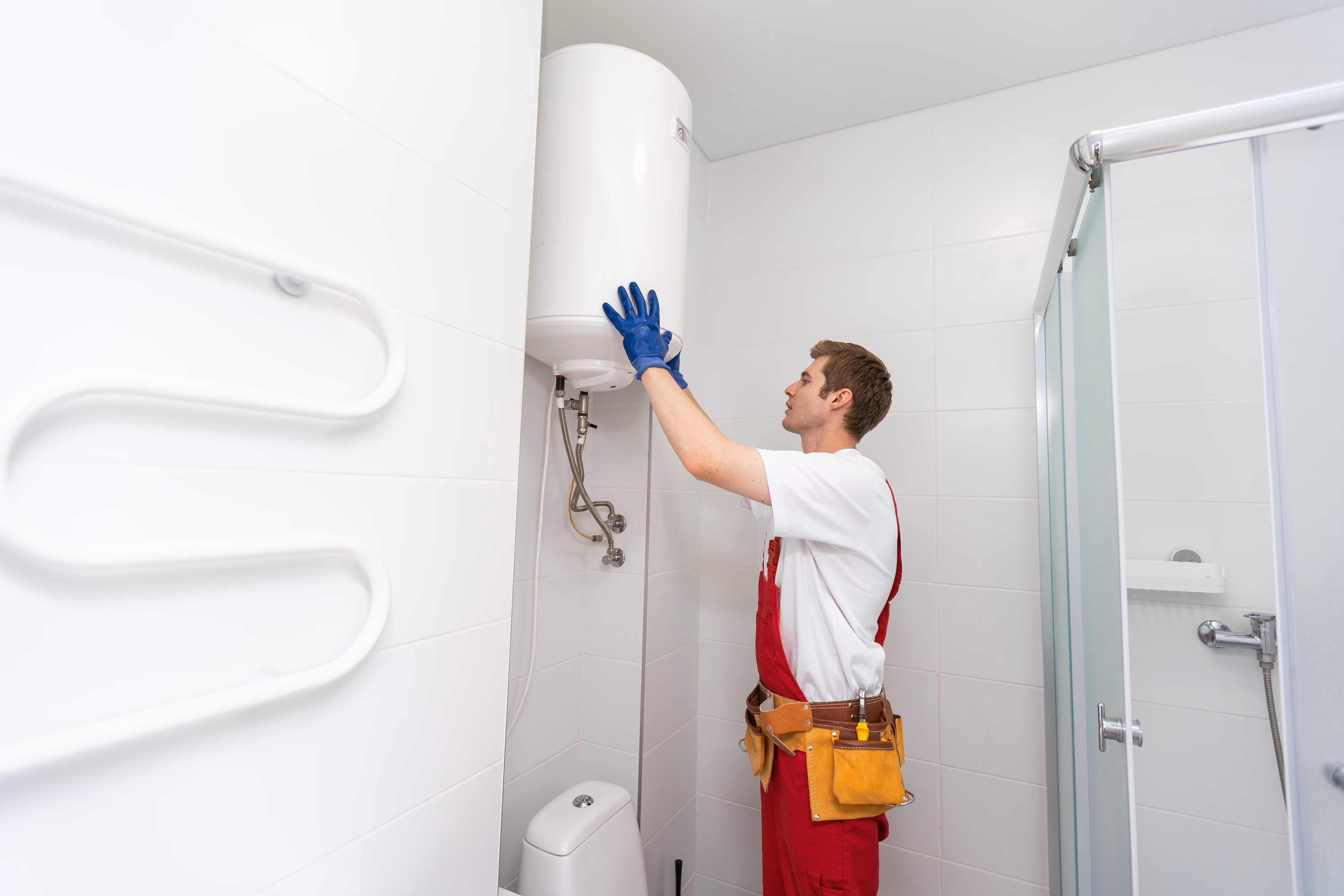 A technician working on a boiler in a bathroom.