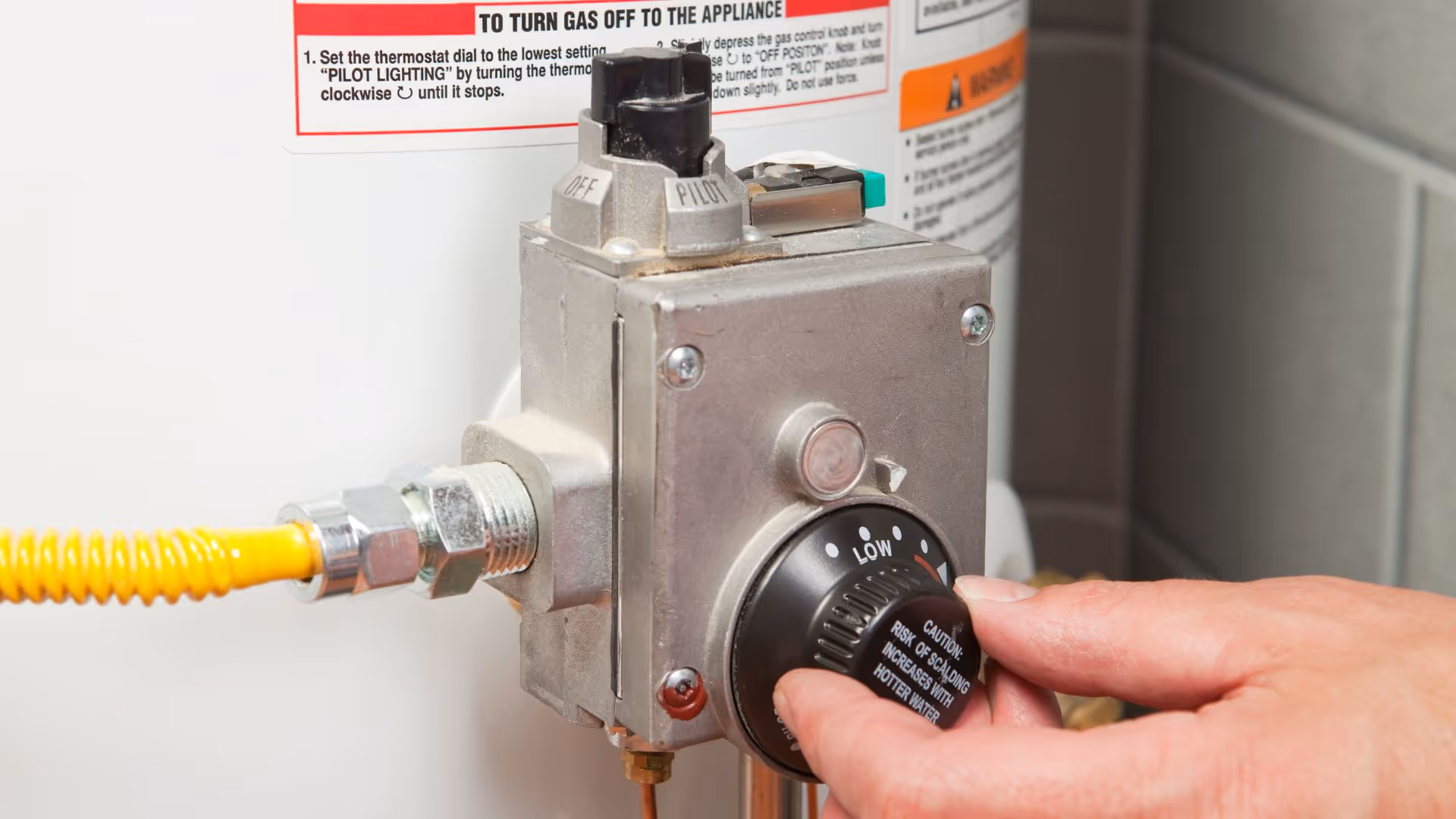 Changing temperature on water heater dial.