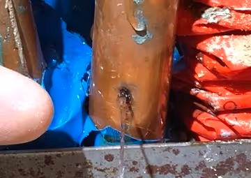 A hole in the copper pipe is leaking