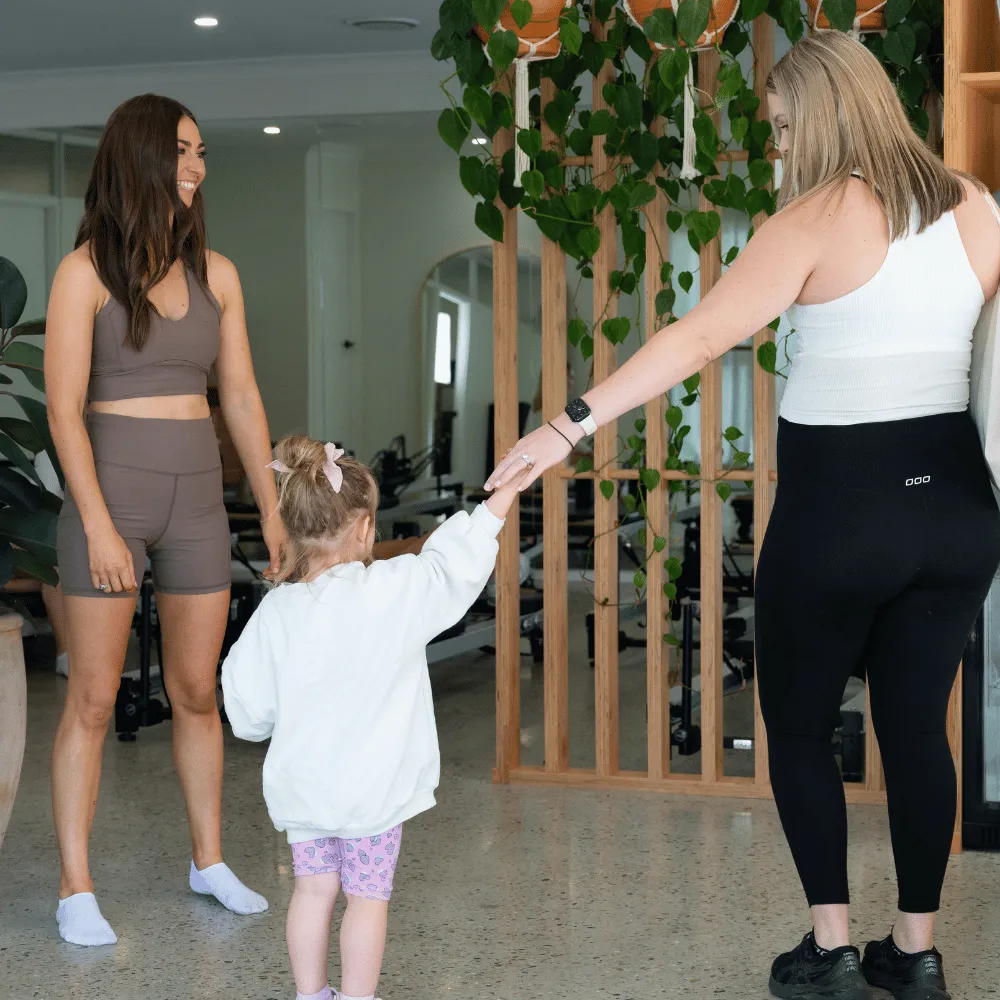 Mum holding her toddler's hand in the studio