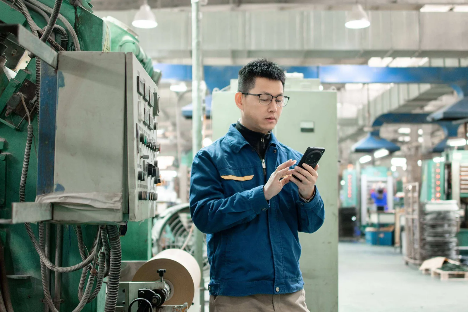 Factory worker inspecting machine.