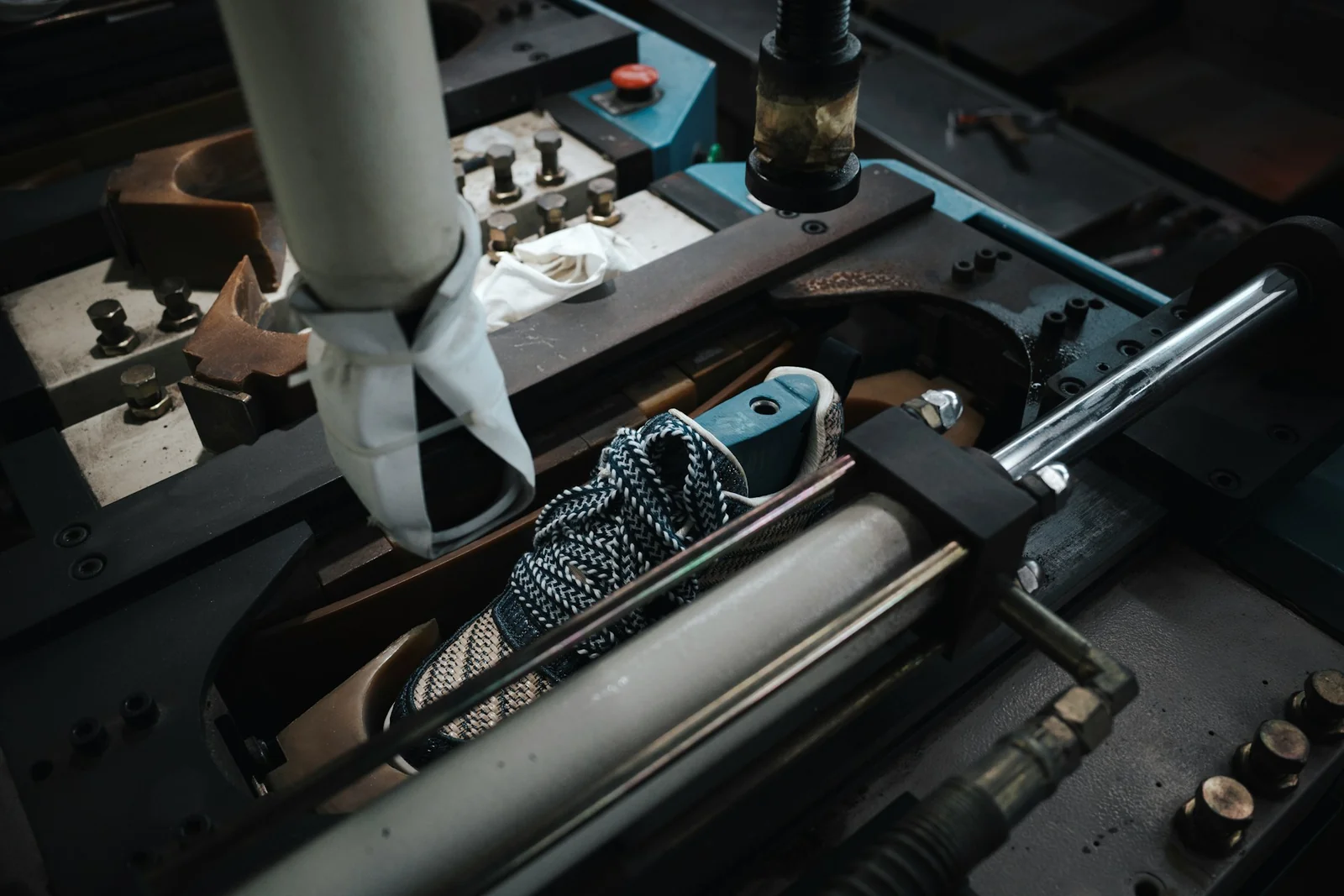 A shoe positioned in production machinery at a footwear factory.