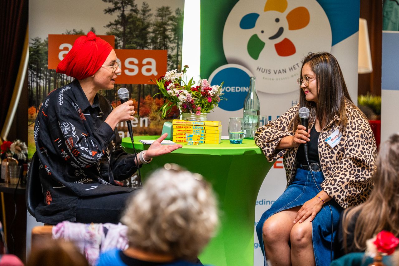 Artemis Kubala in the role of interviewer, hosting a conversation in front of a public.