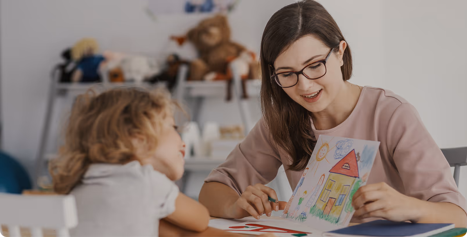 A woman and a child are looking at a colorful book.