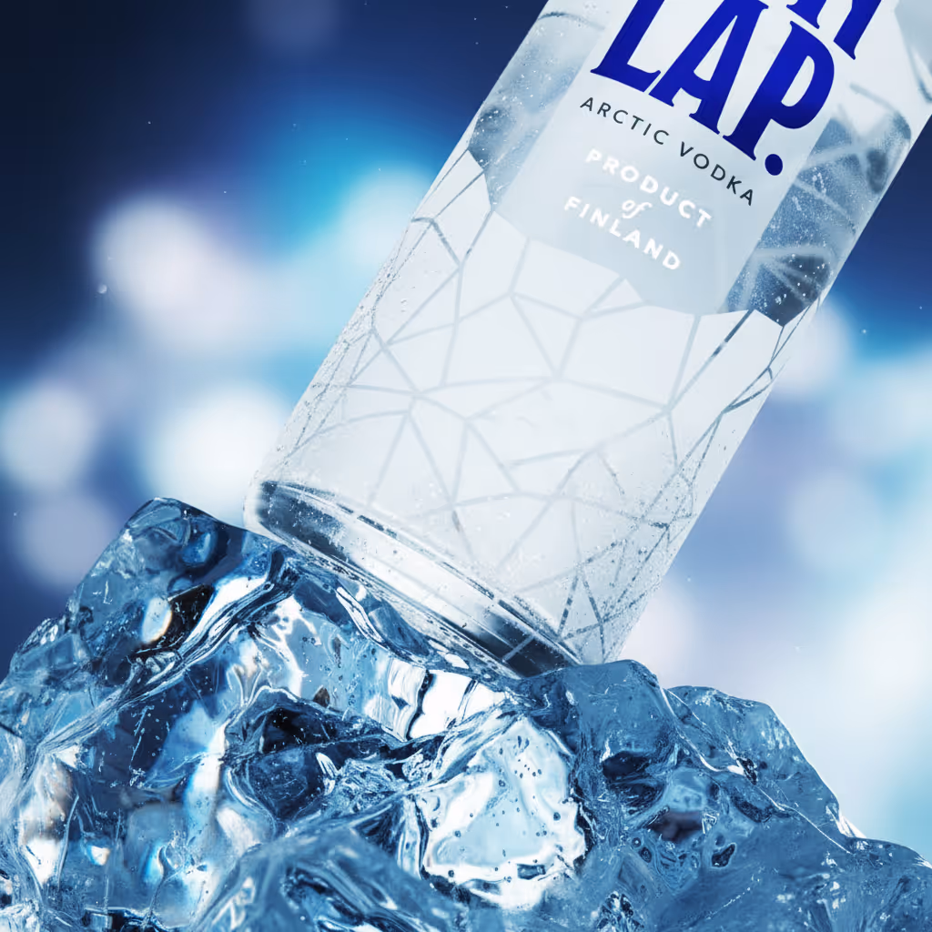 Close-up of a vodka bottle tilted on a pile of clear ice with a blue-toned blurred background.