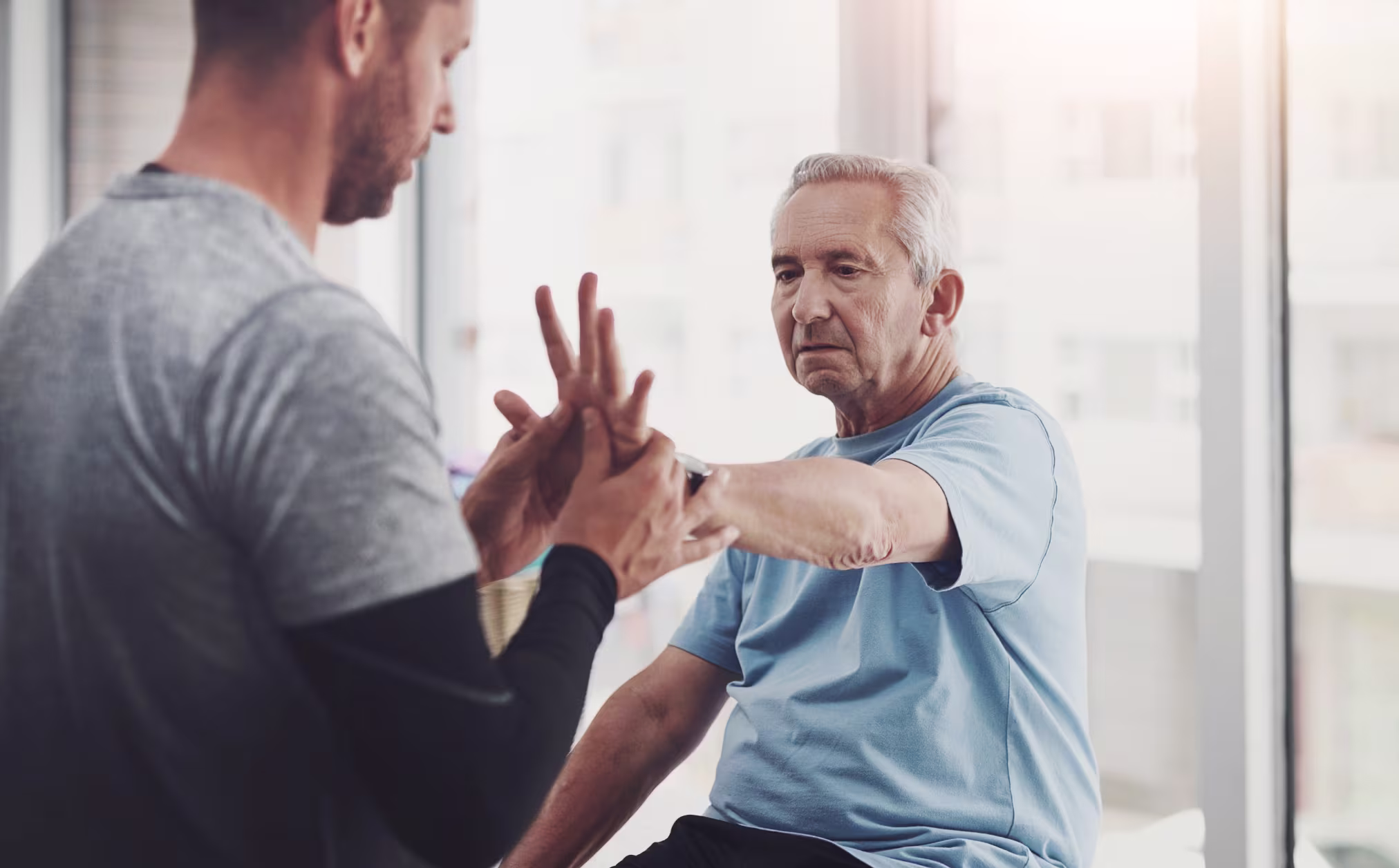 Elderly man doing rehabilitation exercise with a therapist