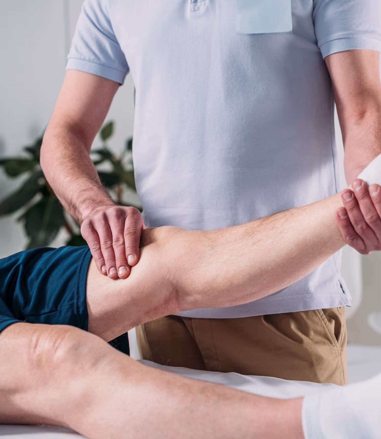 Physiotherapist holding and stretching a patient’s leg during treatment