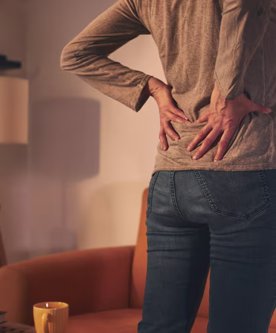 Person holding lower back in pain