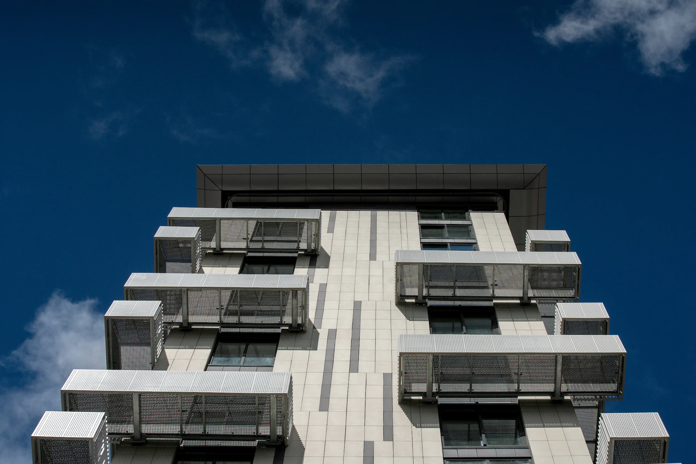 Upward view of the Belcanto façade showcasing projecting Sleeper balconies with perforated Attache Balustrade elements.