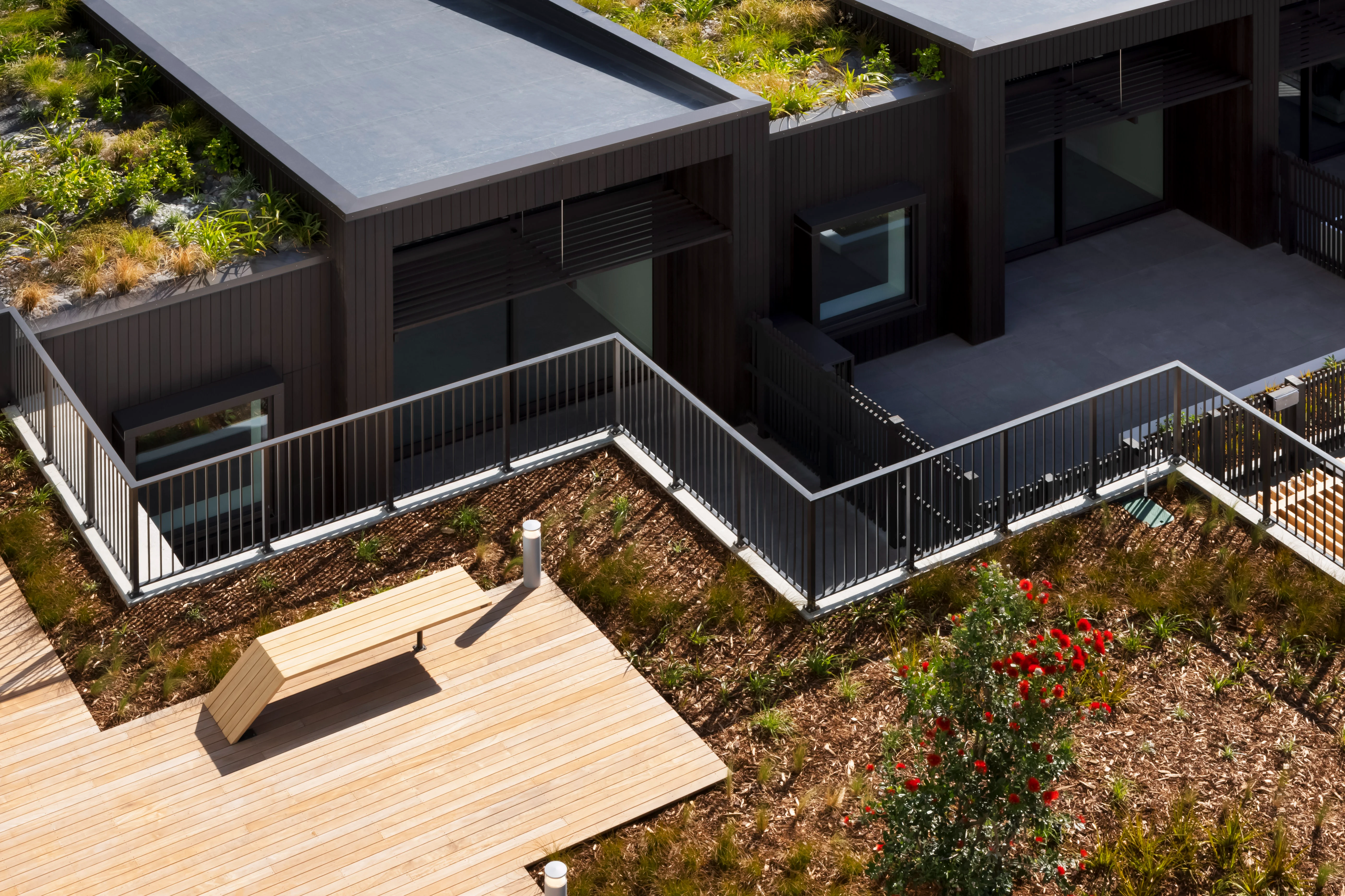 Landscaped terrace at Belcanto featuring black Attache Balustrade in Alliance Style around elevated outdoor areas.