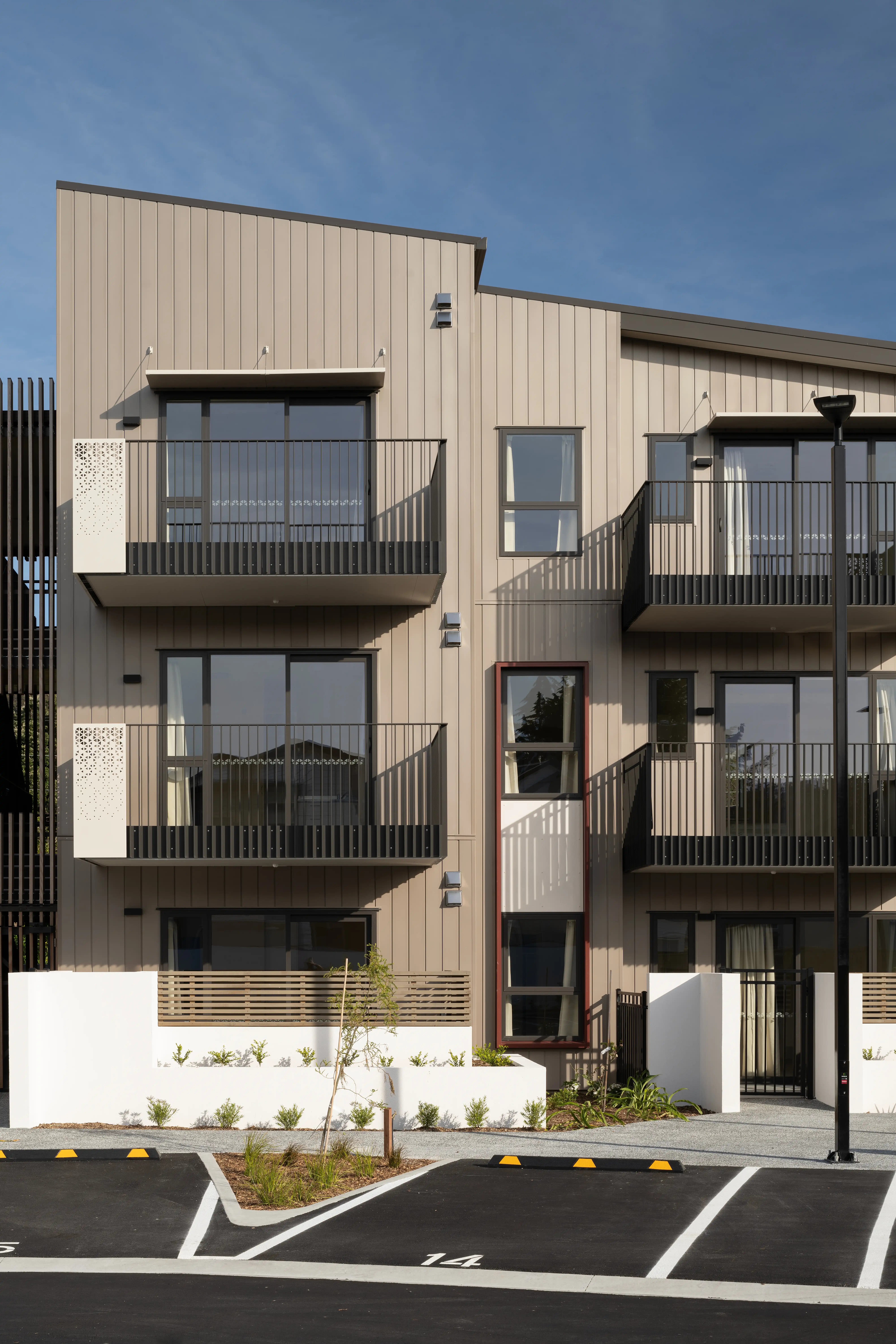 Nine-square-metre community housing balconies at Oxford Terrace, sized for seating, plants and a washing line.