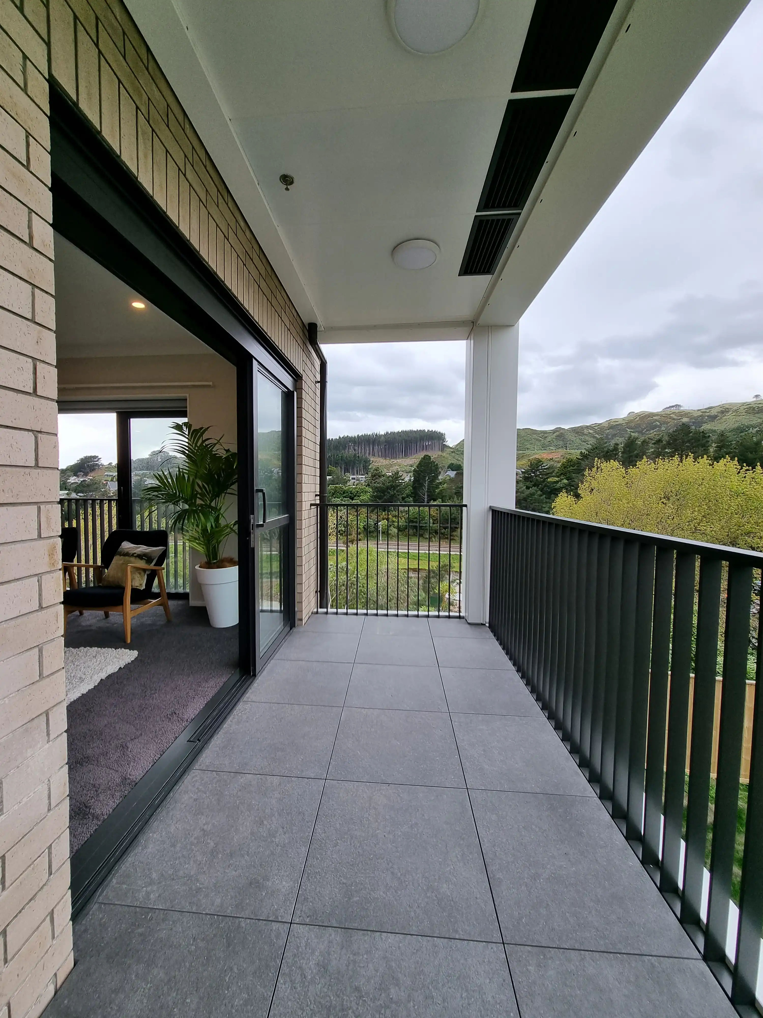Grappler balcony with a porcelain tiled floor and vertical aluminium balustrade at Summerset Kenepuru