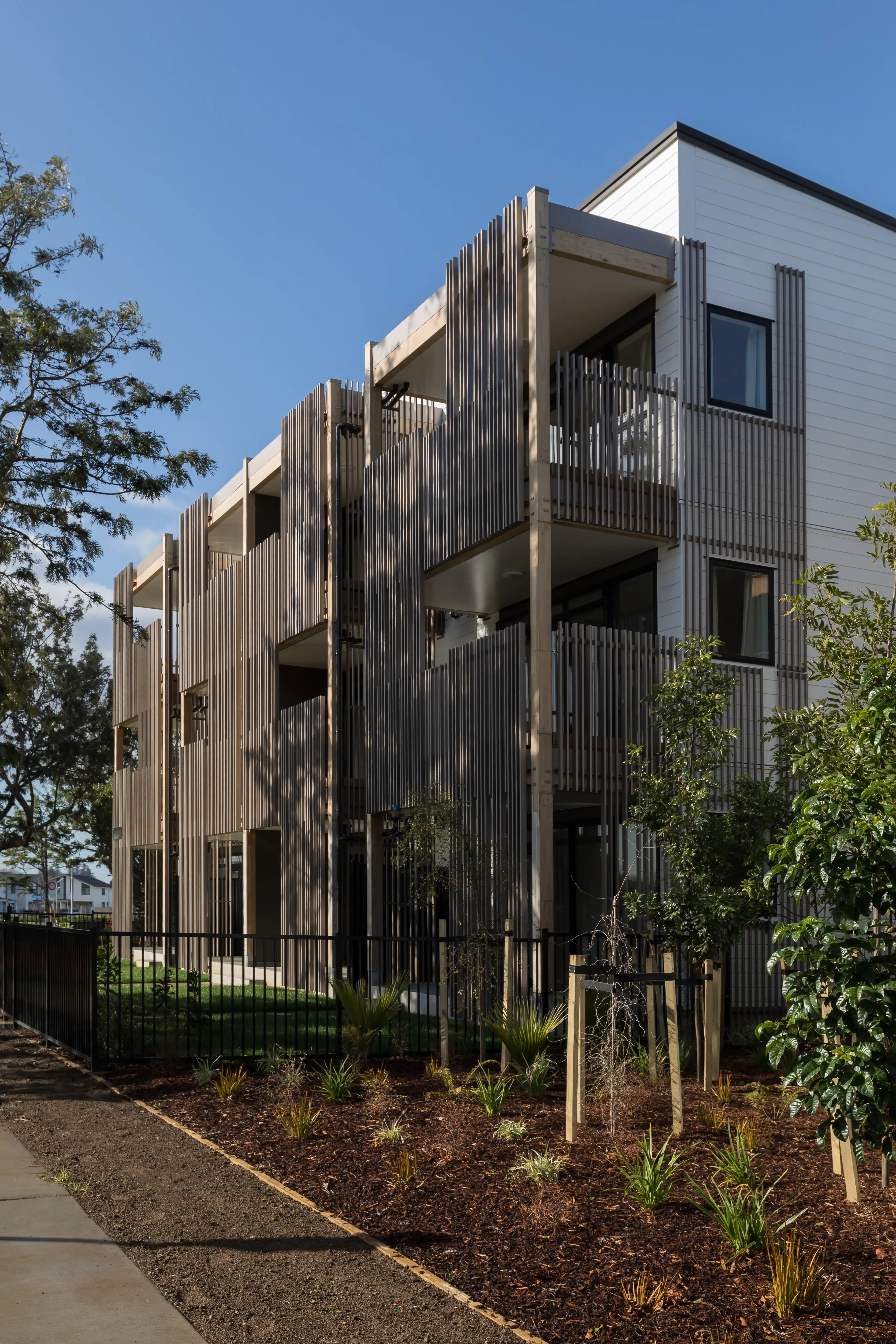 Three-storey walk-up apartments at Bader Ventura with bronze-look aluminium balustrades and screens