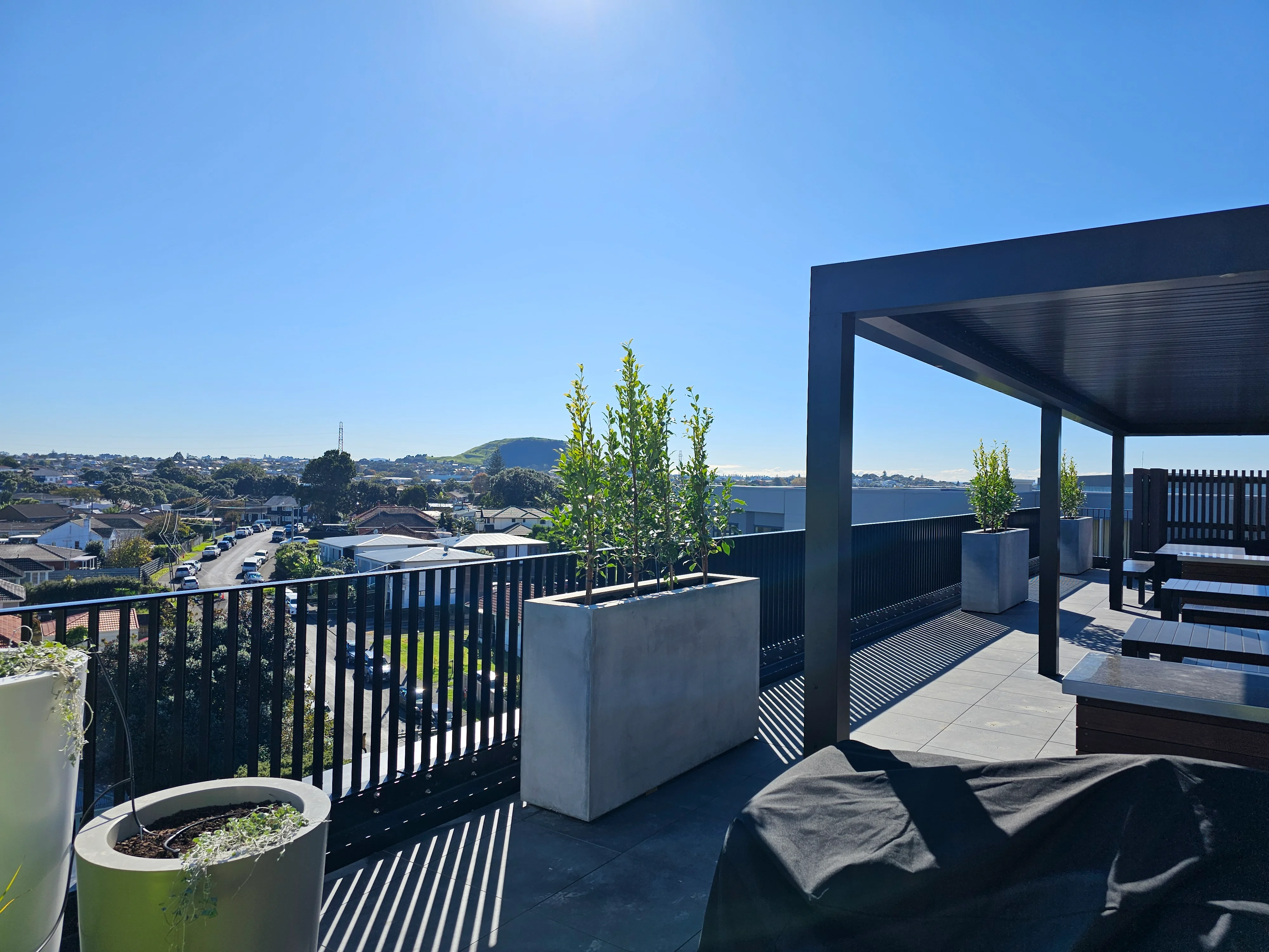 Rooftop balcony at Resido Sylvia Park, edged with vertical aluminium fins matching the apartment balconies below.