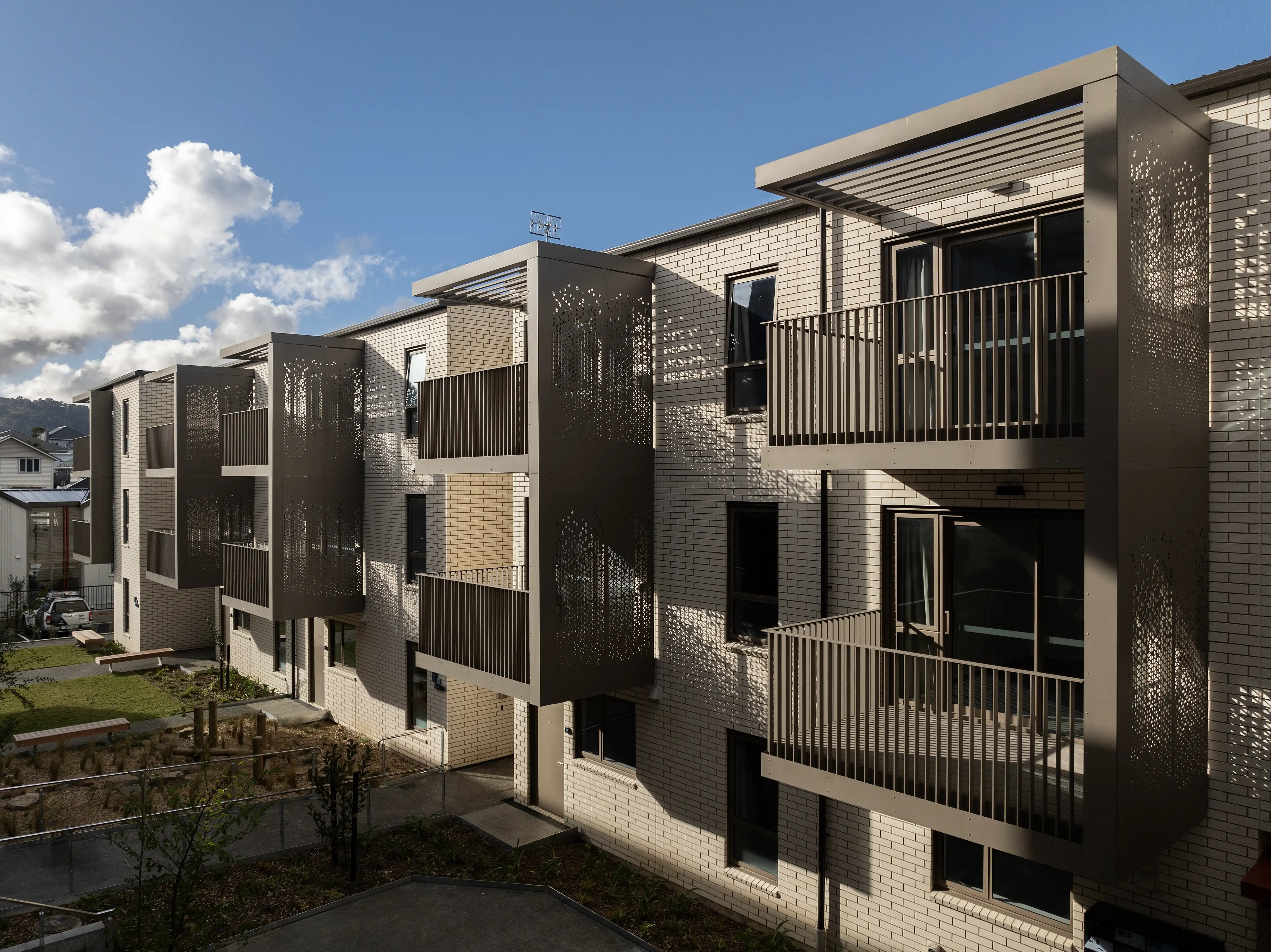 Te Ō social housing on Rolleston Street, Mount Cook, with cantilevered balconies adding depth to flat facades.