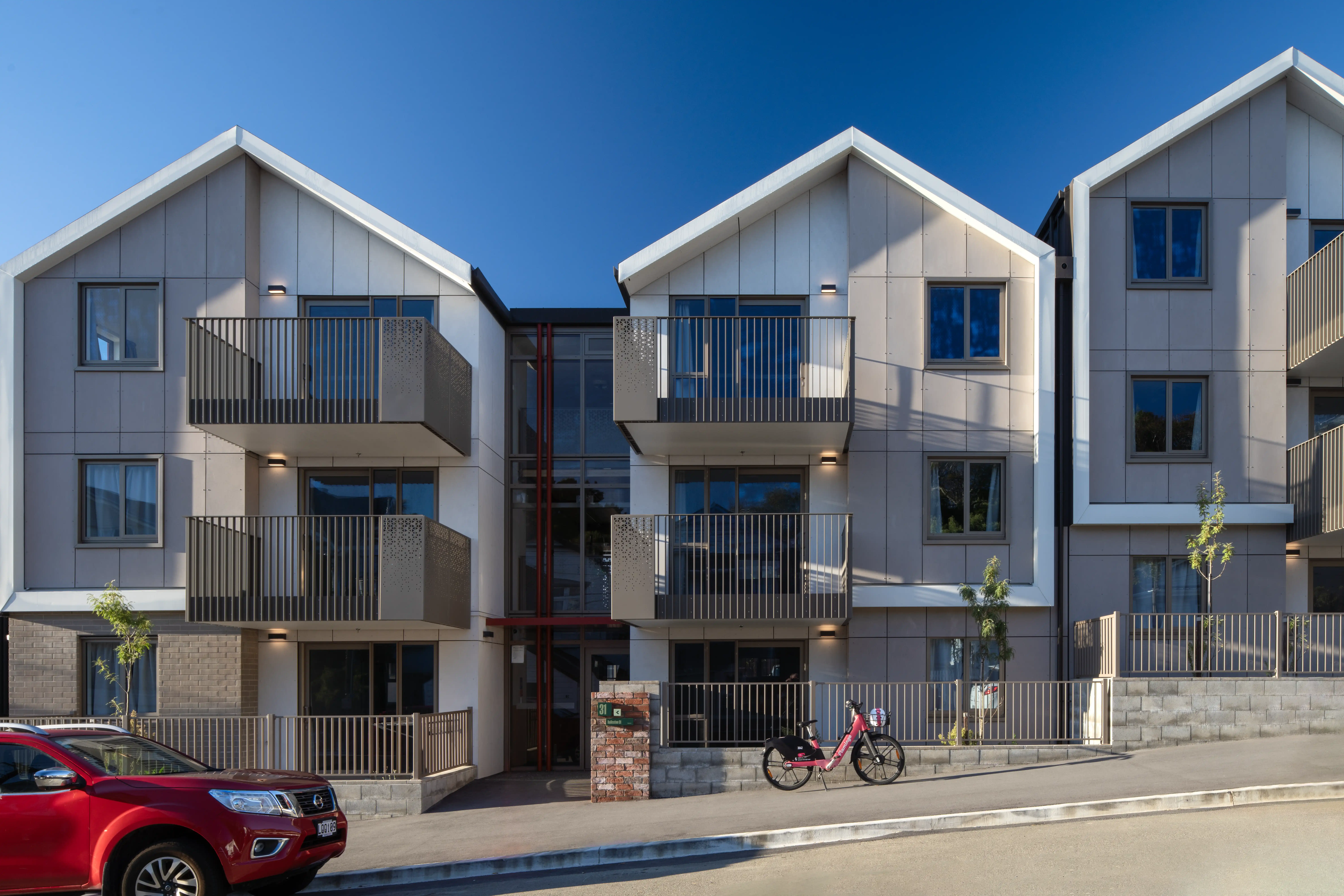 Cantilevered balconies at Te Ō leave the ground level free of posts for pathways, play and community space.